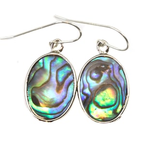 May include: A pair of silver earrings with oval-shaped abalone shell insets. The iridescent shell features shades of blue, green, and purple.