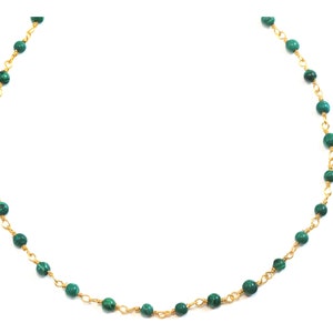 Puede incluir: Un collar de cadena de oro con cuentas de malaquita verde.