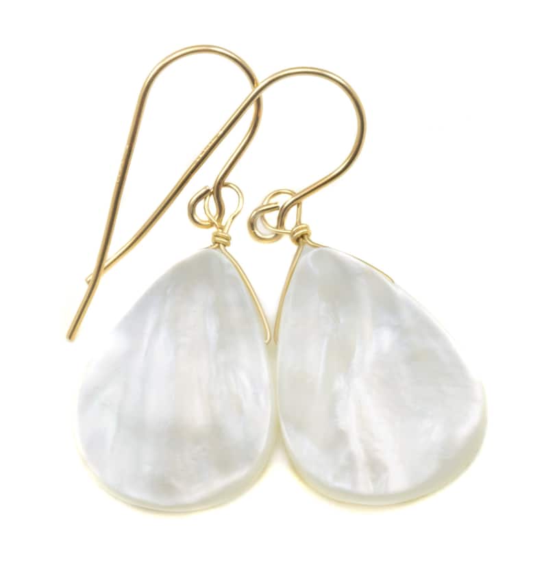 May include: A pair of gold teardrop earrings with white mother of pearl stones.