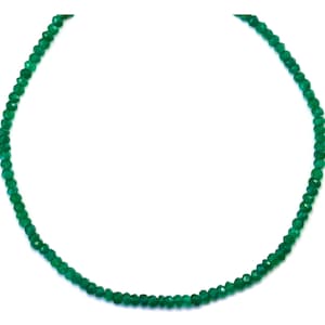 Könnte beinhalten: Eine Halskette aus grünen Edelsteinen mit facettierten Perlen. Die Kette ist auf einem dünnen Draht gefädelt und etwa 45 cm lang.