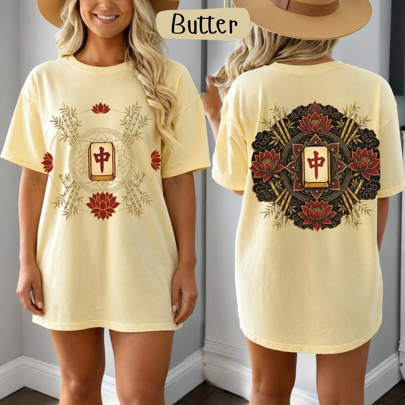 May include: Pale yellow t-shirt with front and back designs. The front has a circular graphic with bamboo, lotus flowers, and a Chinese character. The back features a similar design. The shirt has a relaxed, oversized fit.