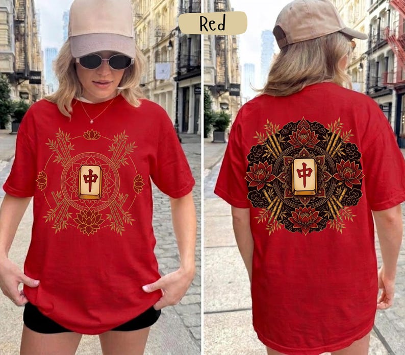 May include: Red t-shirt with a gold and black Mahjong tile design on the front and back. The design includes lotus flowers, bamboo stalks, and a central tile. The shirt is a short-sleeved, casual style.