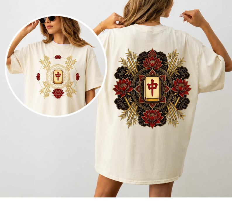 May include: Cream-coloured t-shirt with a Mahjong tile design. The front design features a central tile surrounded by bamboo and lotus flowers. The back design is a larger version of the same motif, with a central tile and intricate floral and bamboo elements.