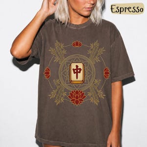 May include: Espresso-coloured t-shirt with a circular Mahjong design. The design features a central tile, bamboo, lotus flowers, and a gold border. The shirt is a relaxed fit and the text "Espresso" is visible.