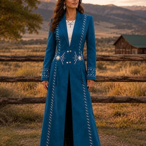 May include: A long, teal-colored coat featuring a notched lapel, long sleeves, and a front button closure. The coat is embellished with silver-toned studs arranged in vertical lines and two decorative silver oval concho accents at the waist.