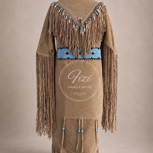 May include: A tan suede jacket featuring long fringe along the sleeves and a V-shaped yoke. It includes a blue beaded waistband with red accents, white and blue beadwork on the yoke, and hanging leather ties with blue beads at the hem.