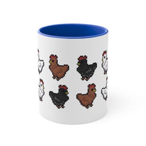Puede incluir: Taza de cerámica blanca con interior azul, con un patrón repetido de pollos pixelados en marrón, negro y blanco. Los pollos tienen crestas rojas. Un diseño divertido y peculiar para los amantes de las aves.