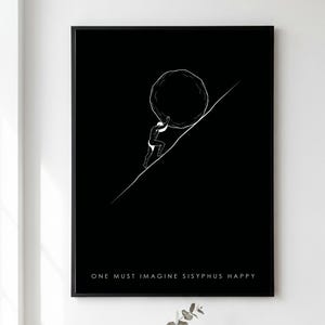 Op de afbeelding: Een zwart ingelijste kunstprint met een witte lijntekening van een figuur die een grote rotsblok een steile diagonale helling opduwt. De tekst "ONE MUST IMAGINE SISYPHUS HAPPY" is in witte hoofdletters onderaan de zwarte achtergrond gedrukt.
