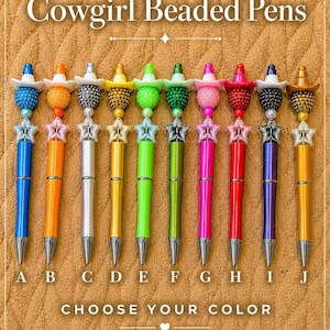 May include: A collection of ten beaded pens with a cowgirl theme. Each pen features a different color barrel and a decorative top with a miniature cowboy hat and star charm. The text "Cowgirl Beaded Pens" and "Choose Your Color" are displayed.