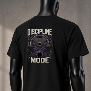 Könnte beinhalten: Ein schwarzes Kurzarm-T-Shirt mit einem Grafikdruck auf der Rückseite und dem Text DISCIPLINE MODE. Das Design zeigt eine violette und schwarze Hantelscheiben-Illustration mit stilisierten Blitzen über dem Wort MODE.
