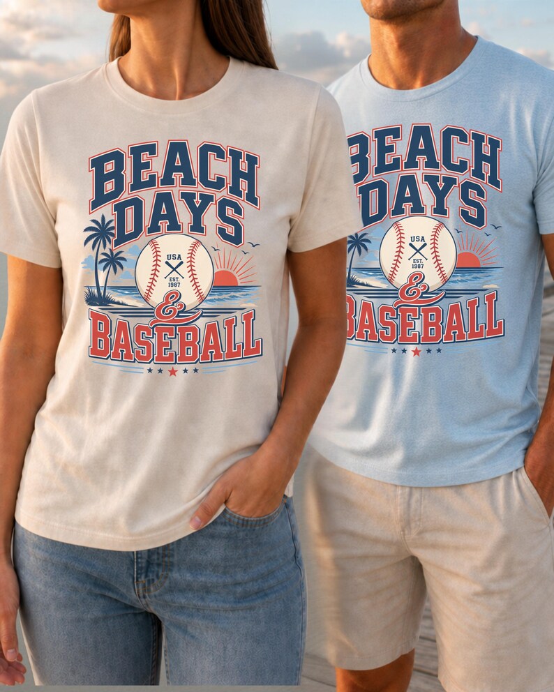 May include: A cream-colored t-shirt and a light blue t-shirt, both featuring a graphic print that reads BEACH DAYS & BASEBALL. The design includes a baseball with USA EST 1997 text, palm trees, a sunset over the ocean, and small birds.