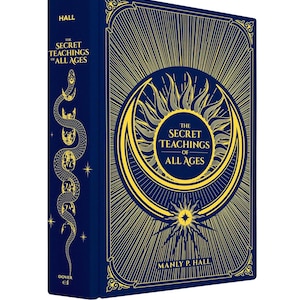 Puede incluir: Un libro de tapa dura titulado "The Secret Teachings of All Ages" de Manly P. Hall. El libro tiene una cubierta azul oscuro con ilustraciones doradas en relieve, incluyendo un sol, una luna creciente y una serpiente. El lomo dice "Hall".