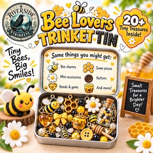 Könnte beinhalten: Eine Metalldose gefüllt mit verschiedenen kleinen Gegenständen wie Bienenanhängern, Wabenformen, Knöpfen, Perlen und einem Miniatur-Honigtopf. Der Innendeckel listet den Inhalt auf. Eine Filzbiene und Gänseblümchen liegen daneben.