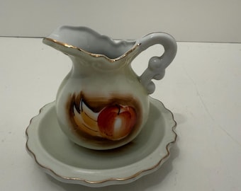 Jarra de cerámica en miniatura con frutas pintadas a mano en la jarra y el plato.