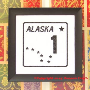 Può includere: Design a punto croce in bianco e nero di un cartello stradale con il testo "ALASKA 1" e una stella. Il cartello presenta anche una piccola costellazione di stelle.