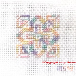 ThreadworX 10592 Variegated Rainbow Embroidery Floss Wildflowers thread has a gradient of pastel pink, orange, yellow, green, blue, and purple and is shown here stitched in a geometric cross stitch pattern.