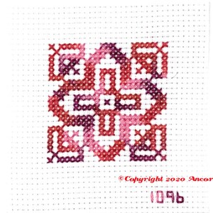 ThreadworX 1096 Variegated Embroidery Floss Renaissance thread has a repeating gradient of dark corals, pink, and red-purple and is shown here stitched in a geometric cross stitch pattern.