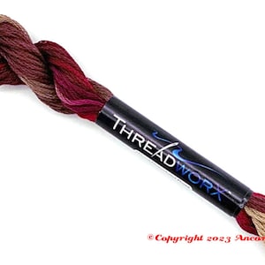 May include: A skein of embroidery floss in shades of brown, red, and beige. The floss is wrapped around a black label with the text "THREADWORK" in blue and white.