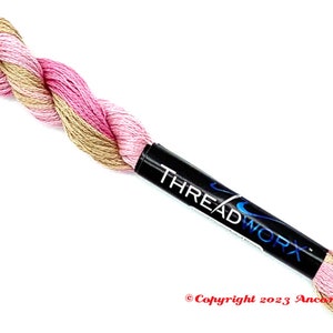 May include: A skein of pink and beige embroidery floss with the brand name "THREADWORK" printed on the label.