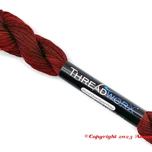 May include: A skein of hand-dyed Threadworx floss in shades of red and brown. The label reads "THREADWORX Hand Overdyed Floss". The floss is made of 100% cotton and is suitable for embroidery and cross-stitch projects.