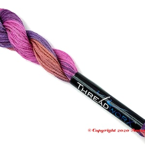 May include: A skein of embroidery floss in shades of purple, pink, and brown. The floss is wound around a black spool with the text "THREADWORX" printed on it.
