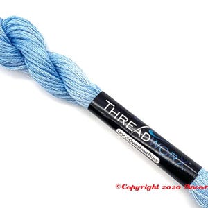 May include: A skein of light blue hand-dyed floss with a black label that reads "THREADWORKX Hand Overdyed Floss" and "Copyright 2020 Ancona Crafts".