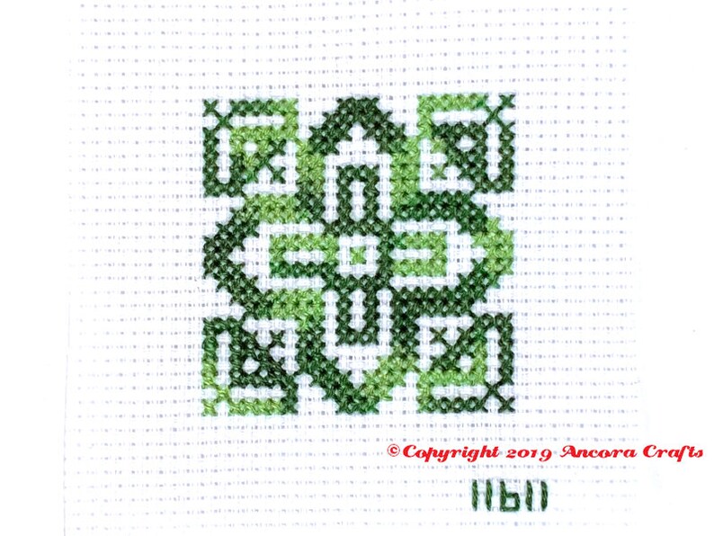 ThreadworX 11611 Variegated Embroidery Floss Tropical thread has a repeating gradient of stunning tropical and forest greens and is shown here stitched in a geometric cross stitch pattern.