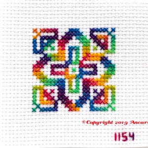 This ThreadworX 1154 rainbow embroidery floss is a gorgeous variegated blend of bright pink, orange, yellow, green, blue, and purple, and is shown here stitched in a geometric cross stitch pattern.