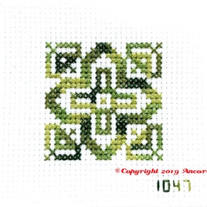 ThreadworX 1047 Variegated Embroidery Floss Tropical Green thread has a repeating gradient of tropical greens and is shown here stitched in a geometric cross stitch pattern.