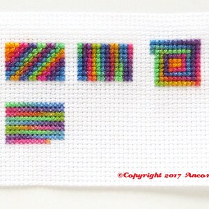 This ThreadworX 1154 rainbow embroidery floss is a gorgeous variegated blend of bright pink, orange, yellow, green, blue, and purple, and is shown here stitched in a sampler that shows how this floss stitches up diagonally, in serpentine, and spiral