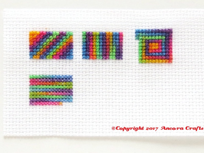 This ThreadworX 1154 rainbow embroidery floss is a gorgeous variegated blend of bright pink, orange, yellow, green, blue, and purple, and is shown here stitched in a sampler that shows how this floss stitches up diagonally, in serpentine, and spiral