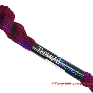 May include: A skein of purple and burgundy embroidery floss with the label "THREADWORX Hand-Dyed Cotton Floss" on the spool.