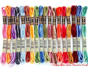 May include: A collection of 18 embroidery floss spools in various colors, including pink, orange, purple, blue, brown, yellow, green, red, and beige. Each spool is labeled with a number, such as 48, 51, 52, 53, 67, 69, 90, 92, 93, 94, 99, 105, 106, 107, 111, 115, 121, and 125.