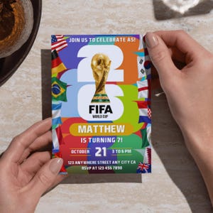 May include: A rectangular birthday invitation card featuring the FIFA World Cup trophy, the text JOIN US TO CELEBRATE AS 2026 FIFA WORLD CUP, MATTHEW IS TURNING 7, OCTOBER 21, 3 TO 6 PM, and various national flags on a colorful, abstract background.