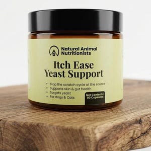 May include: A jar of "Itch Ease Yeast Support" for dogs and cats, with a black lid and a light green label. The label includes the text "Natural Animal Nutritionists" and "Net Contents: 90 Capsules". The jar sits on a wooden cutting board.