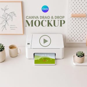 May include: A white printer with a green play button graphic is printing a card with the text "MOCK & ROLL". The image also includes a framed botanical print, a coffee mug, and a succulent plant.