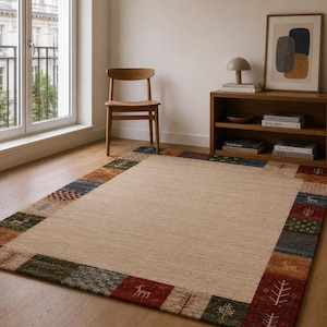 Alfombra de patchwork anudada a mano con borde decorativo, estampado tribal de ciervos en color crema, estilo rústico bohemio para sala de estar.