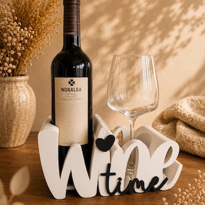 Könnte beinhalten: Ein weißer Weinflaschen- und Glashalter aus Holz mit dem schwarzen Schriftzug "Wine time" und einem kleinen schwarzen Herzsymbol. Der Halter ist so gestaltet, dass er eine Weinflasche und ein Weinglas sicher in seinen Aussparungen hält.