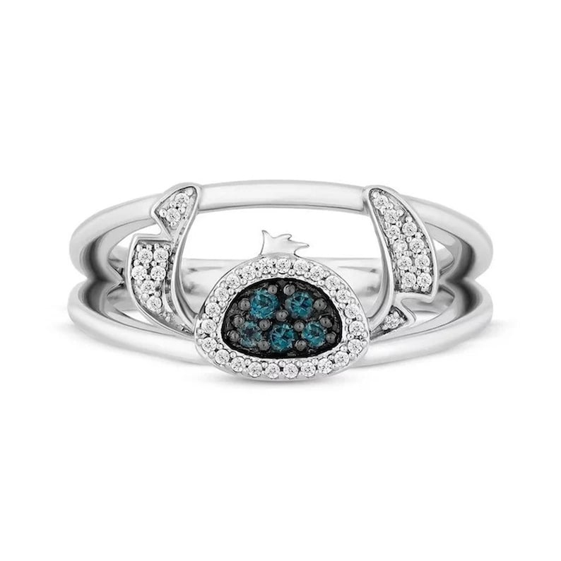 Op de afbeelding: Een zilveren ring met een centraal cluster van blauwe edelstenen, omringd door een halo van witte edelstenen. De ring heeft een unieke vorm met gebogen accenten en extra witte edelstenen.