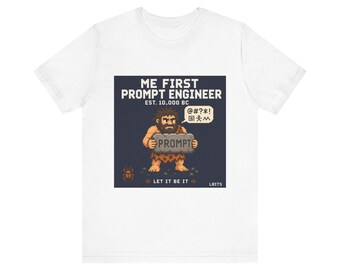 May include: White t-shirt with a graphic of a pixelated caveman holding a stone tablet that reads "PROMPT". The text above the caveman says "ME FIRST PROMPT ENGINEER EST. 10,000 BC". Below the caveman is the text "LET IT BE IT".