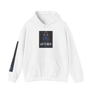 Peut inclure: Un sweat à capuche blanc avec une poche avant et un cordon de serrage. L'avant présente un graphisme rectangulaire avec un scarabée bleu et le texte "LET IT BE IT". La manche gauche a un motif noir et bleu avec le texte "LBTS".