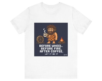 May include: White t-shirt with a pixelated image of a caveman holding a coffee cup. The graphic includes a wheel, fire, and the text: "BEFORE WHEEL. BEFORE FIRE. AFTER COFFEE. LET IT BE IT."