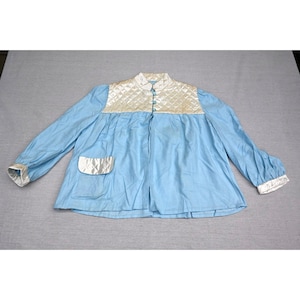Puede incluir: Una chaqueta azul claro con un canesú acolchado blanco y puños acolchados a juego. La prenda incluye un bolsillo delantero único con solapa acolchada blanca, un cuello mao y una fila vertical de tres botones de color azul claro al frente.
