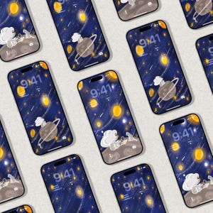 以下が含まれることがあります： 宇宙をテーマにした壁紙が表示された複数のスマートフォン。デザインには、リングのある惑星、漫画のキャラクター、黄色のオーブが濃い青色の背景に配置されています。画面には9:41と表示されています。