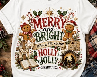 Puede incluir: Una camiseta blanca con un gráfico navideño que incluye dos galletas de jengibre, una cruz de madera con un libro abierto, un pesebre y el texto Merry and Bright, Jesus is the Reason, Joy to the World, Holly Jolly y Christmas 2026.