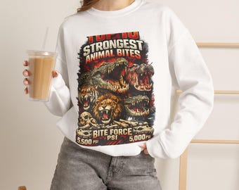 Puede incluir: Una sudadera blanca de manga larga con un estampado gráfico titulado TOP 10 STRONGEST ANIMAL BITES. El diseño muestra ilustraciones de un cocodrilo, hipopótamo, tigre y león con el texto BITE FORCE 5.500 PSI y 5.000 PSI en la parte inferior.