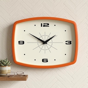 May include: A rectangular wall clock with an orange frame and an off-white face. Black numerals mark the hours, with black hands indicating the time. The clock has a retro design, suitable for home decor.