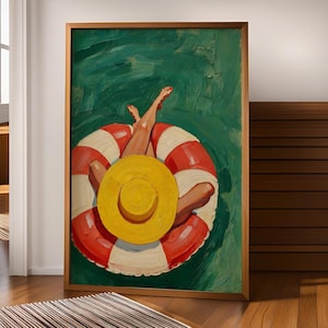 May include: A framed oil painting depicting a person floating in deep green water on a red and white striped circular pool float. The person wears a bright yellow sun hat, with legs extended upward, showing red painted toenails against the water.