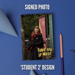May include: A rectangular photograph featuring a person in a black robe and red and gold scarf, standing before banners. The text "THANK YOU SO MUCH!" is printed in yellow script on the lower right. The photo is labeled "SIGNED PHOTO" and "STUDENT 2' DESIGN".