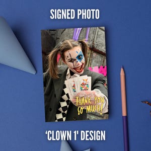 May include: A signed photo featuring a person with clown makeup, pigtails, and a dark blazer over a checkered shirt. The person holds playing cards and wears a lace glove. The text 'THANK YOU SO MUCH!' is printed in yellow on the photo.
